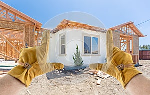 Male Contractor Hands Framing Completed Section of House Being Built