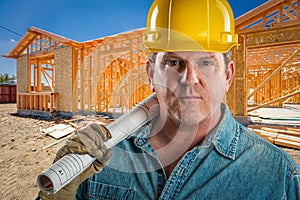 Male Contractor in Hard Hat Holding Floor Plans At Construction Site