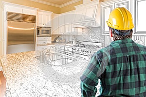 Male Contractor with Hard Hat and Tool Belt Looks at a Kitchen