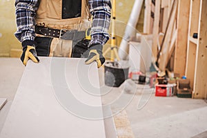 Male Contractor Holding Piece Of Drywall Material