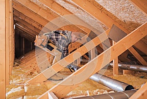 Male Contractor Installs Metal Pipe System In Attic