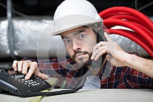male contractor making strange expression while using telephone