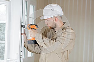 male contractor using drill on window
