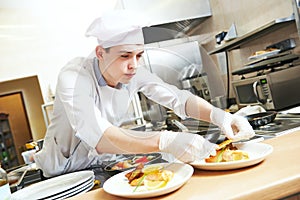 Male cook chef decorating food on the plate