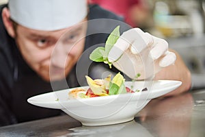 Male cook decorating dish