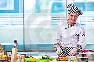 The male cook preparing food in the kitchen