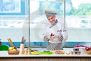 The male cook preparing food in the kitchen