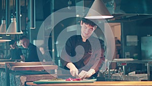 Male cook is smiling while cutting vegetables