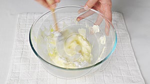 Male cook stirs whipped meringue protein with cooked egg dough and flour with a wooden spatula