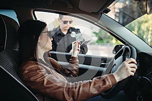 Male cop in uniform writes a fine to female driver