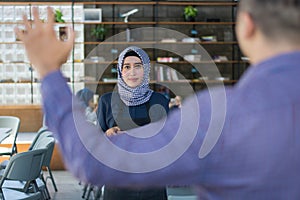 Male costumer calling for hijab female cafe waiters, ready for order