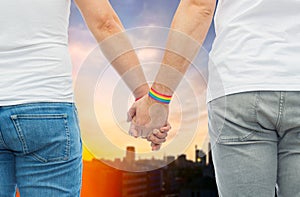 Male couple with gay pride rainbow wristbands