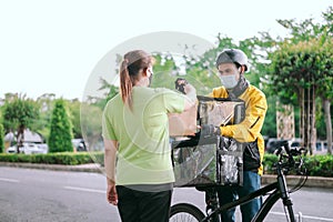 Male courier with bicycle delivered shopping yellow bag to the client.Courier delivery food service
