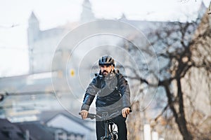 Male courier with bicycle delivering packages in city. Copy space.