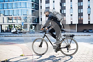 Male courier with bicycle delivering packages in city. Copy space.