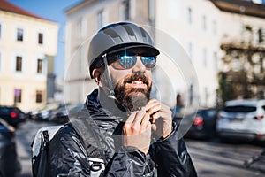 Male courier with sunglasses delivering packages in city.