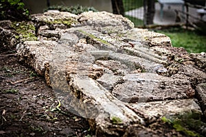 A male craftsman builds a raised bed or wall from rough stones