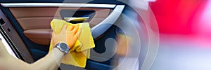 Male craftsman in gloves with microfiber wipes car handle of car closeup