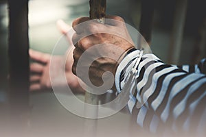 Male criminals was arrested and handcuffed in a dirty cage