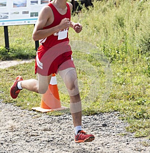 Male cross country runner racing on dirt path