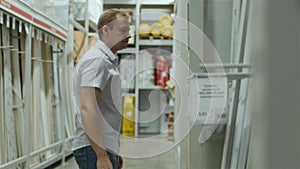 Male customer chooses goods in store of building materials