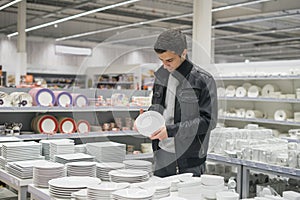 Male customer choosing dinnerware plates