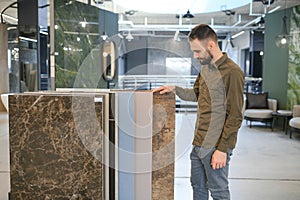 Male customer choosing kitchen ceramic tile in store