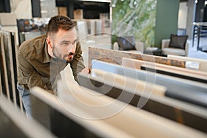 Male customer choosing kitchen ceramic tile in store