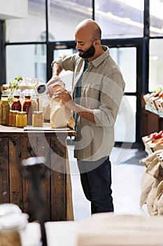 Male customer fills bag with lentils