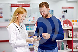 Male customer having a discrete talk with druggist in pharmacy