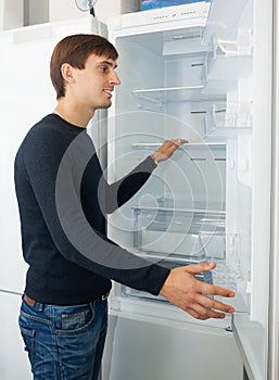 Male customer looking at modern fridges