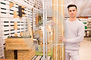 Male customer selecting construction materials in hardware store