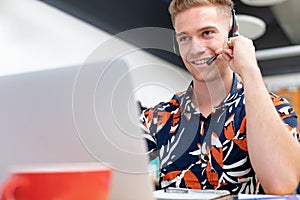 Male customer service executive talking on headset in a modern office