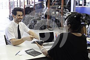 Male customers paying by credit card at counter in auto parts stores. business warehouse motor vehicle. Second-hand car parts