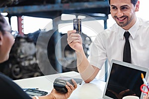 Male customers paying by credit card at counter in auto parts stores. business warehouse motor vehicle. Second-hand car parts