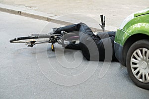 Male cyclist after car accident on road