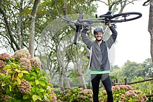 Male cyclist carrying mountain bike