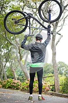 Male cyclist carrying mountain bike