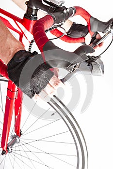 Male Cyclist Hands in Protective Gloves Put on Handlebars While Pressing Front and Rear Brakes Levers Against White