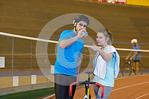 male cyclist holding bottled water in velodrome photo