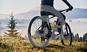 Male cyclist riding bicycle in mountains.