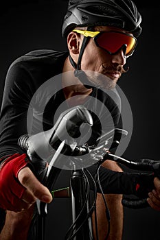 male cyclist riding road bicycle on black background