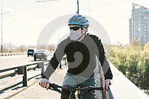 Male cyclist wearing respirator face mask with heavy duty protective filter. Man on bike wearing respirator face mask with heavy