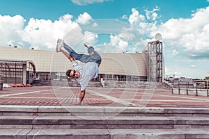 Male dancer dancing in summer city, break dance, fashionable and modern hip-hop dance style. Street lifestyle. Free