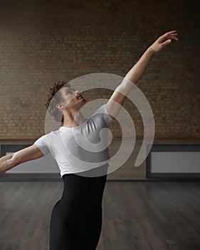 Male dancer practicing in ballet studio holding training class