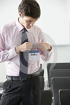 Male Delegate Attaching Name Badge At Conference