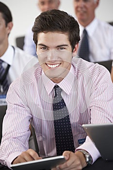 Male Delegate Listening To Presentation At Conference making Not