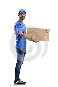 A male deliveryman, on a white background, full-length, with a box