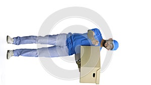 A male deliveryman, on a white background, full-length, with a box, points forward