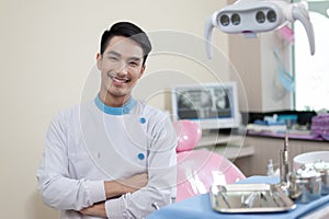 Male dentist crossing armin dental clinic photo